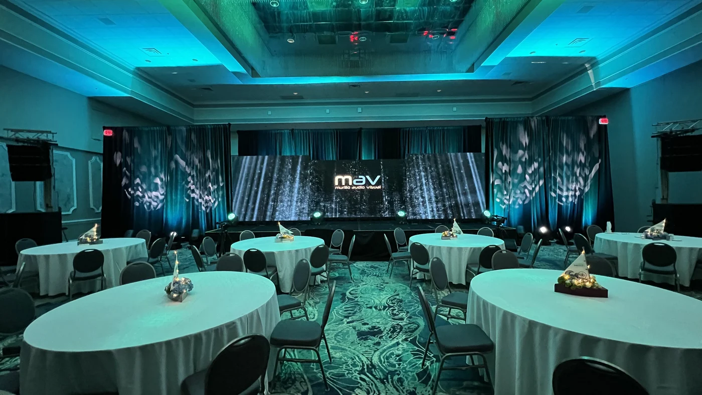 Reception ballroom with teal uplighting set by MAV