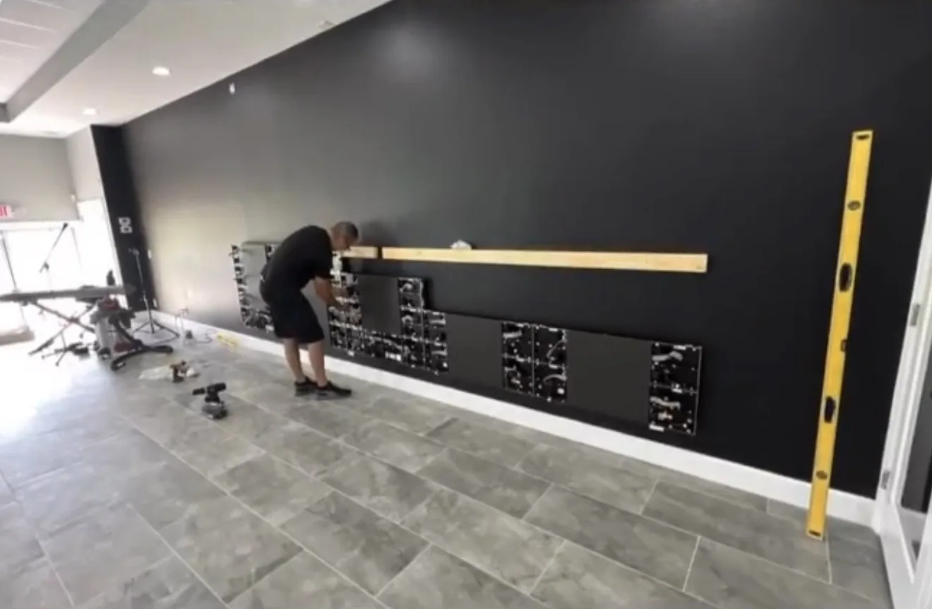 Technician mounting LED panels on the wall